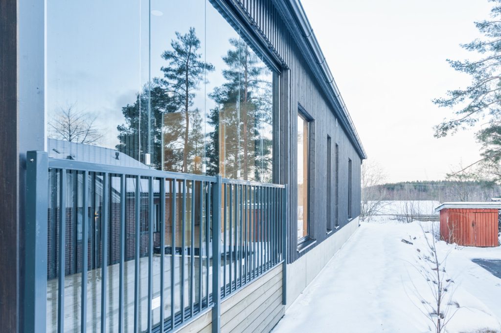 Espoon uudiskohteen paritalon ulkokuva, moderni julkisivu ja suuret ikkunat talvimaisemassa.