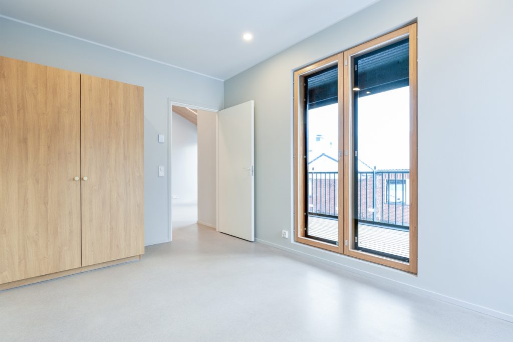 Uudiskohteen paritalon makuuhuone Espoossa, suuret ikkunat ja vaalea sisustus.