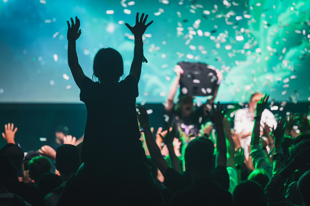 Assembly Summer tapahtuman yleisö juhlimassa kädet ylhäällä konfettisateessa lavan edessä.